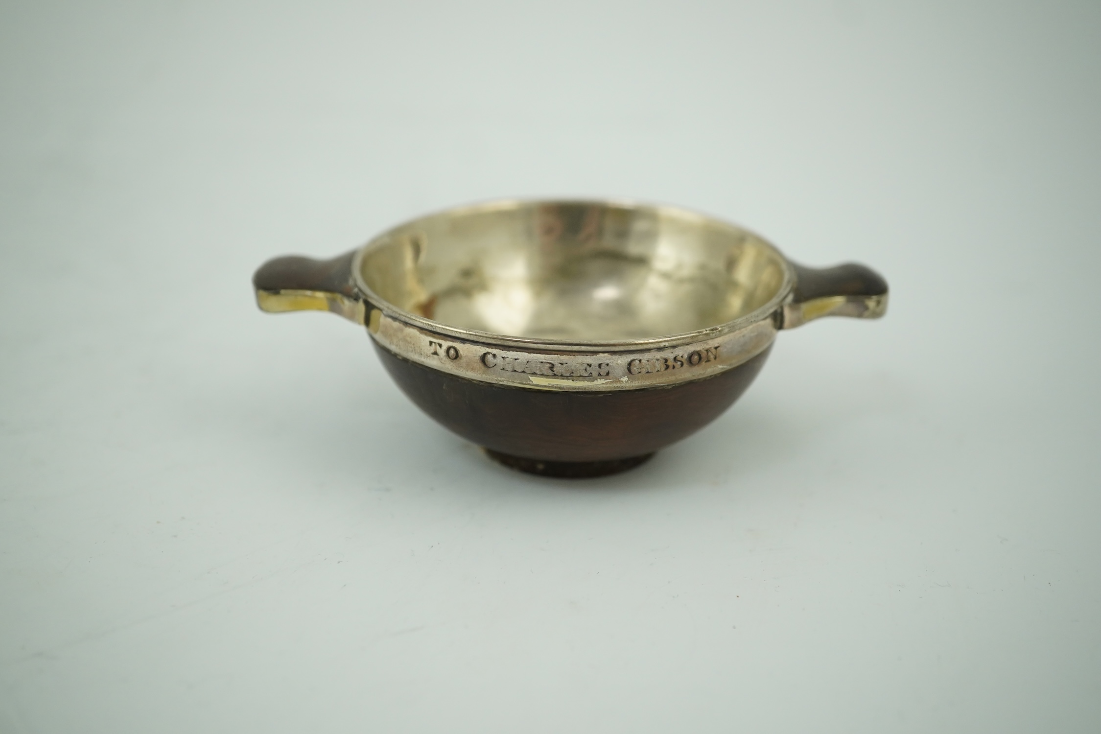 An early 19th century silver mounted yew wood quaich, inscribed 'Scuab As E' to the bowl and 'To Charles Gibson / From A Butter of Faskally' around the rim, dated 1830 beneath one handle, 10.6cm over handles. Condition -